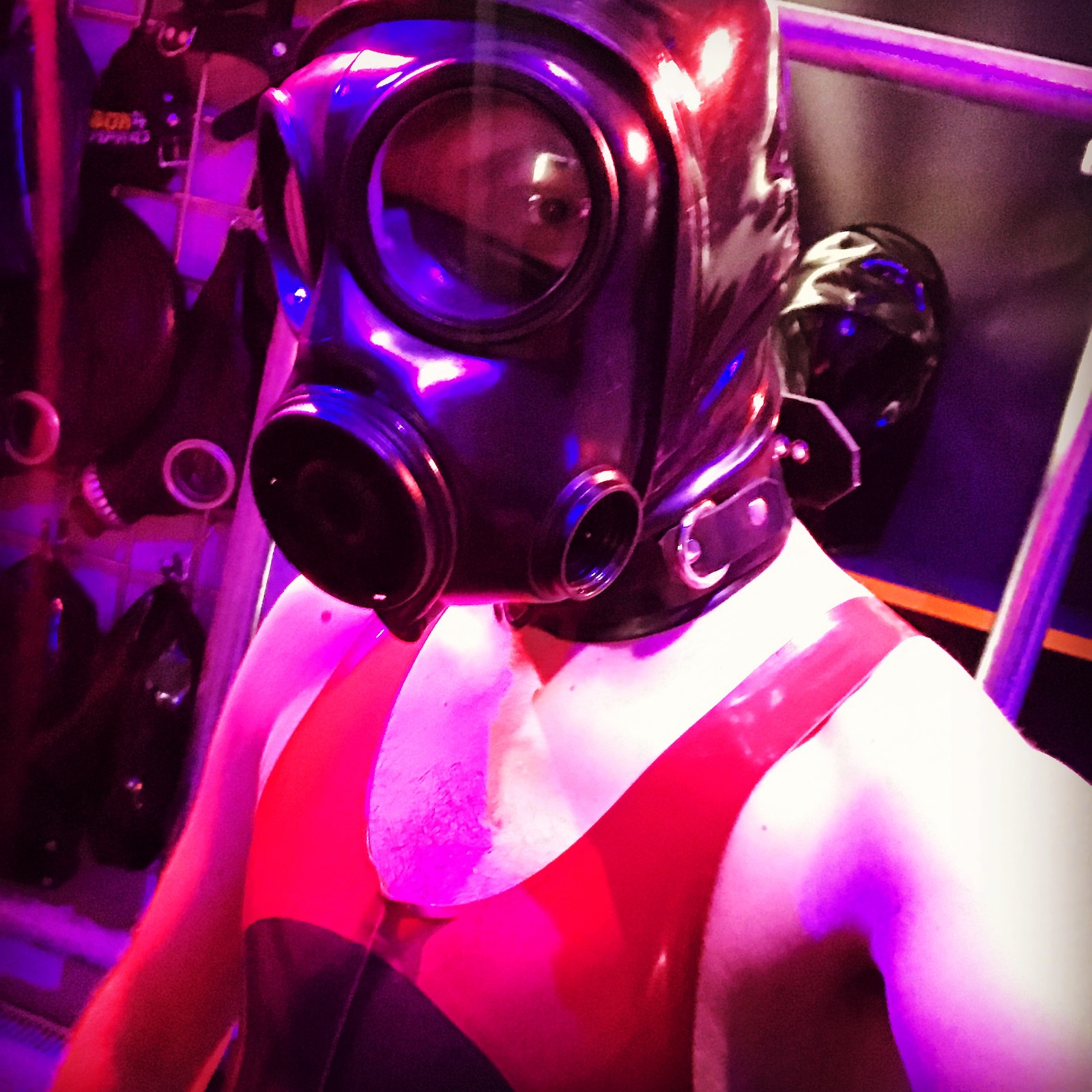 switchLDN in hooded s10 gas mask and red and semi trans latex rubber wrestling suit holding speedcuffs